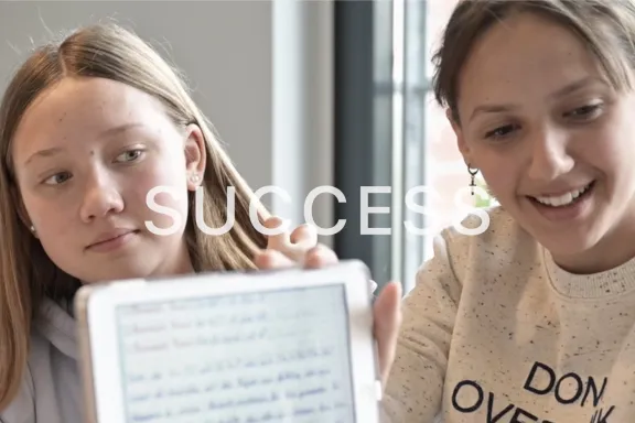 Student and sibling showing work on a screen